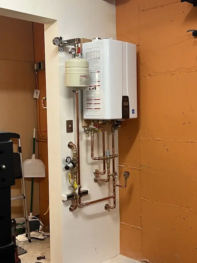 Plumbing technician inspecting water heater connections in Mount Hope